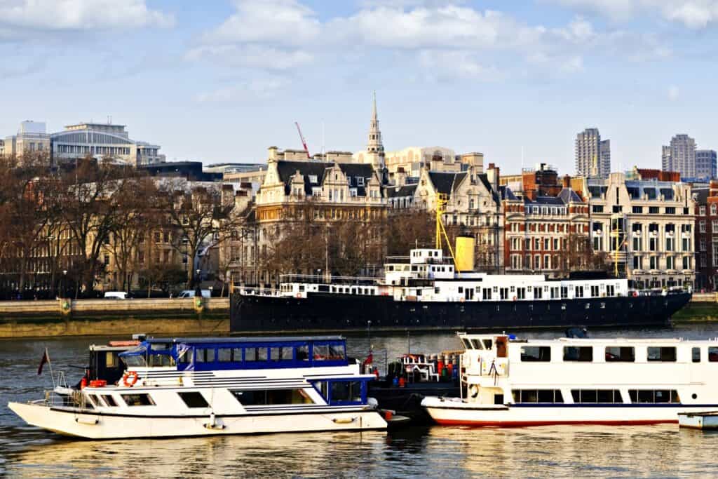 Residential buildings along the River Thames while boats are sailing